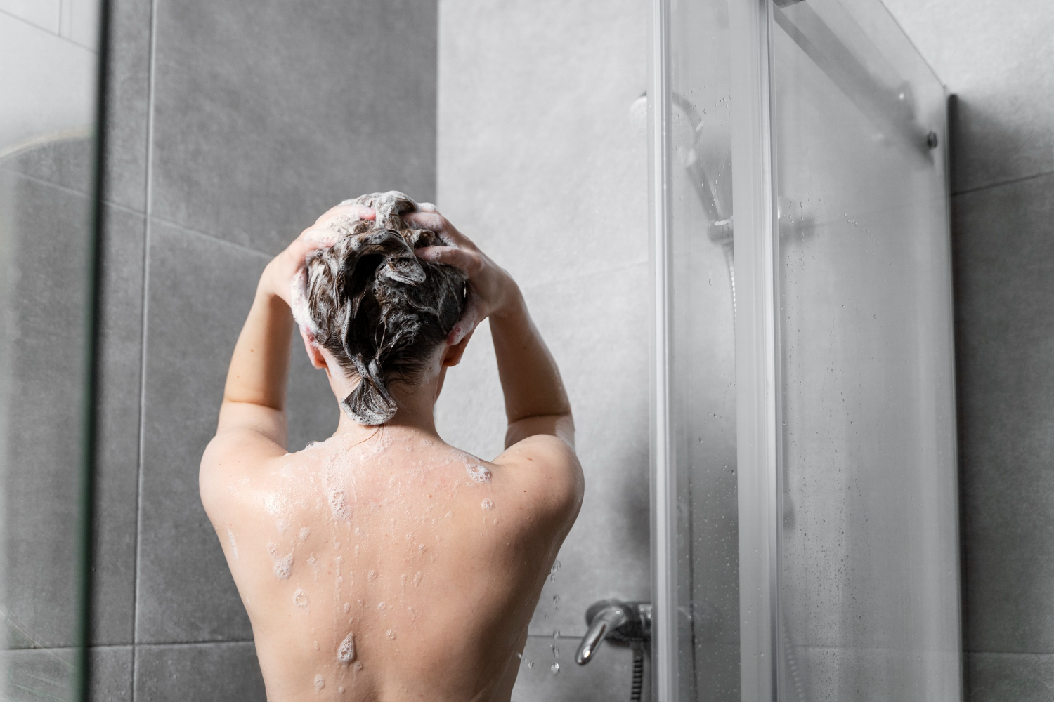 mujer lavando su cabello para limpiar el cuero cabelludo graso