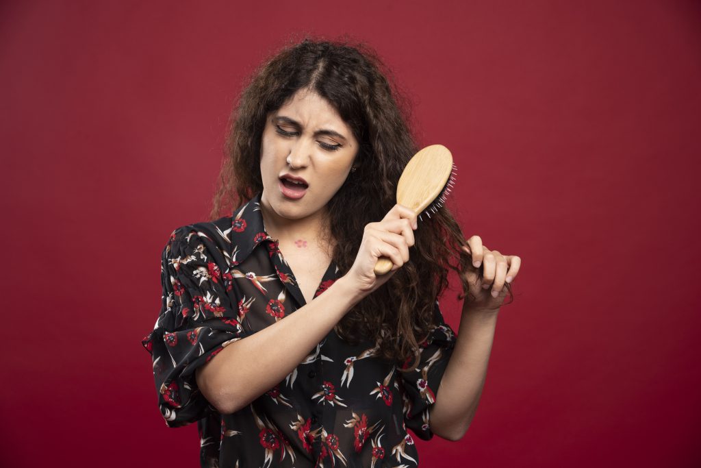 Mujer cepillándose el cabello grueso y frizado en seco